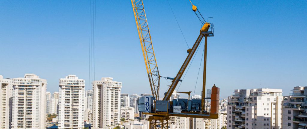 עגורן זרוע מתרוממת בפרויקט מגדל מגורים בפתח תקווה